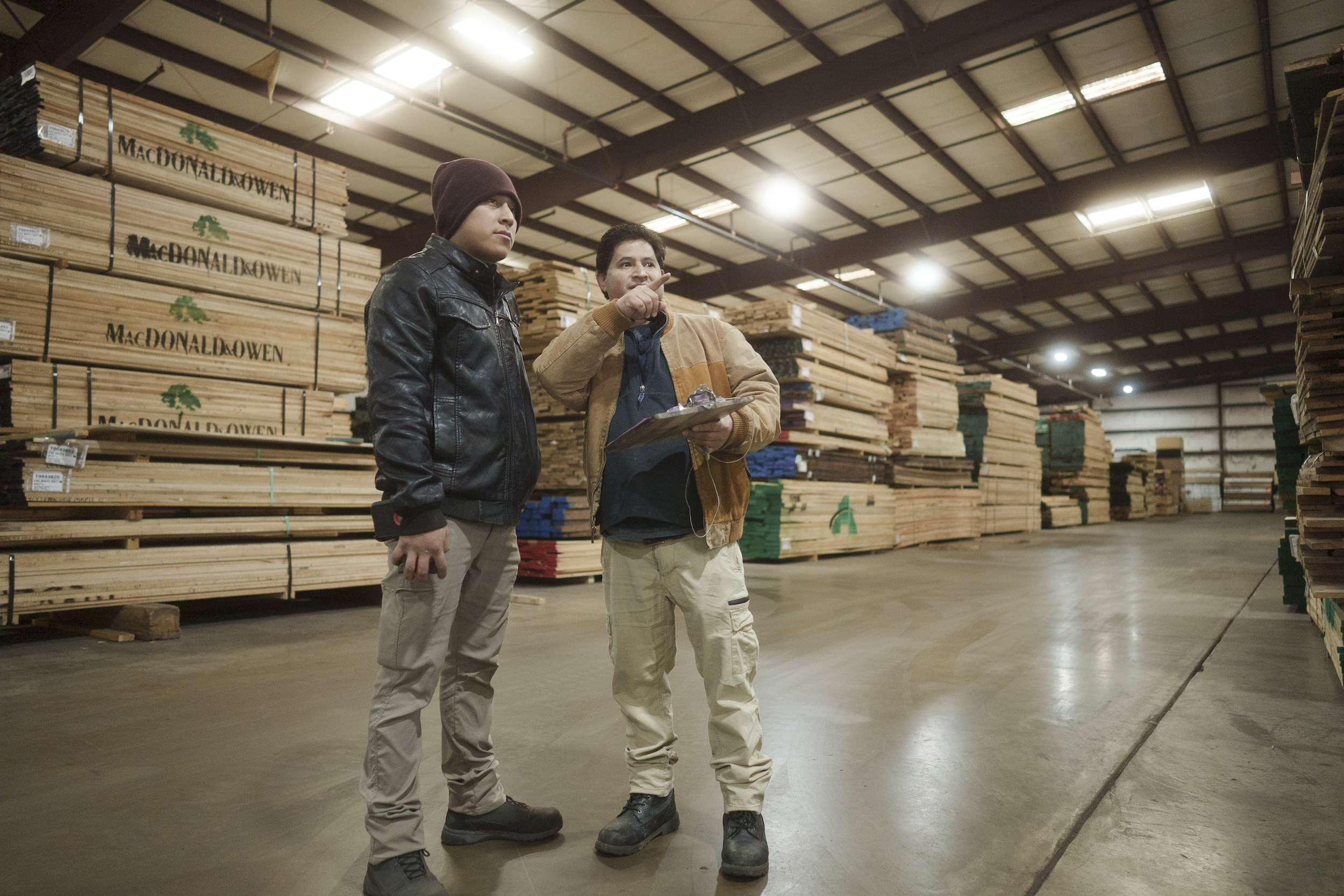 Two employees looking at lumber
